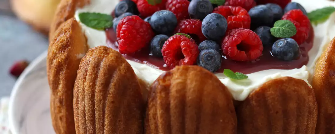 Charlotte mit roten früchten und madeleines