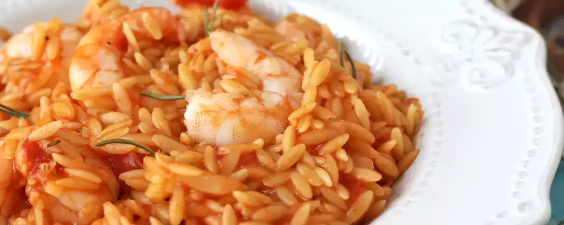 Orzo-nudeln mit tomaten und garnelen, zubereitet wie ein risotto