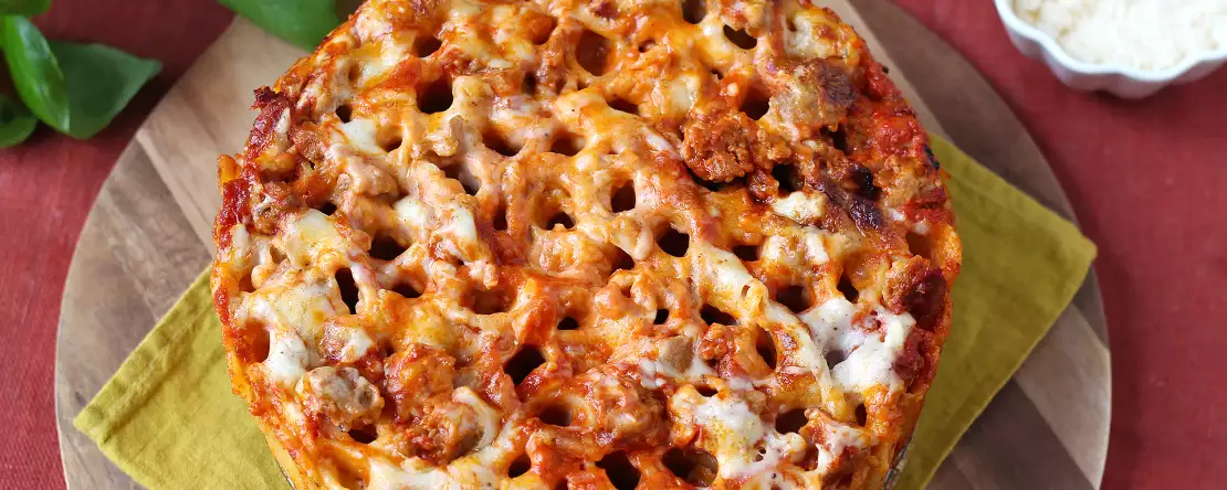 Rigatoni-auflauf aus dem ofen mit wurst, bechamelsauce und mozzarella