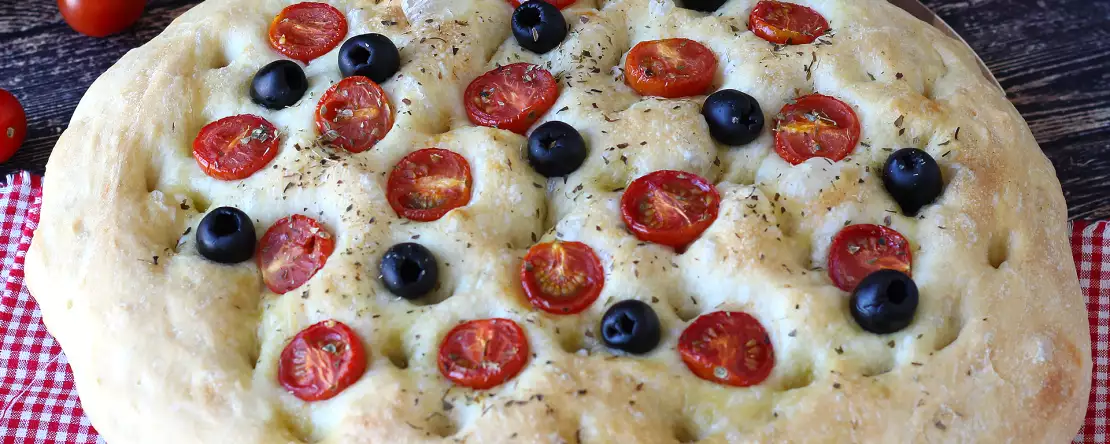 Dicke, luftige focaccia mit kirschtomaten, oliven und oregano