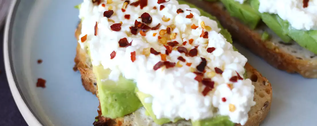 Toast mit avocado und hüttenkäse mit gewürztem honig