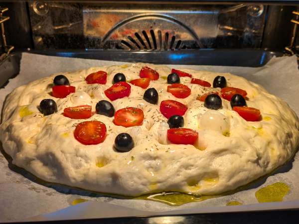 Dicke, luftige Focaccia mit Kirschtomaten, Oliven und Oregano - Zubereitung Schritt 12