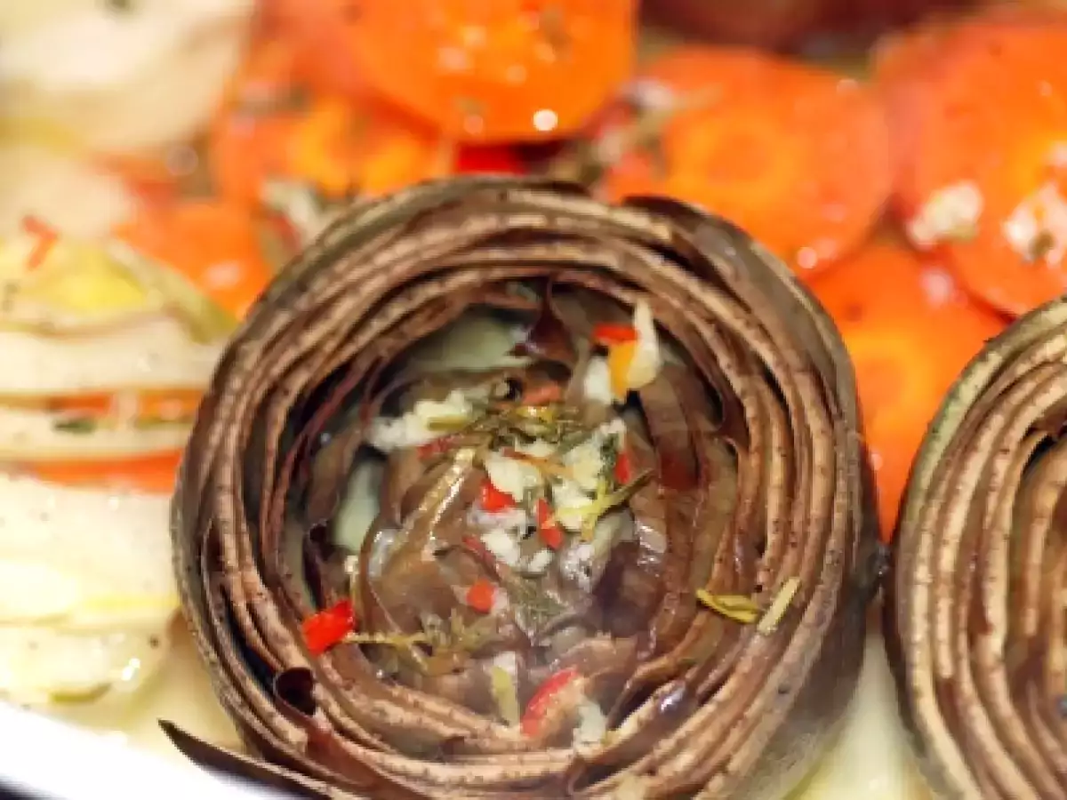 Dampfende frische Artischocken, Fenchel und Karottenstücke in Knoblauch und Chili