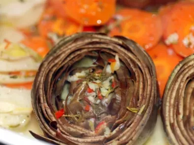 Dampfende frische Artischocken, Fenchel und Karottenstücke in Knoblauch und Chili